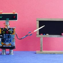 Robot teacher explains modern theory. Classroom interior with empty black chalkboard. Pink blue colorful background